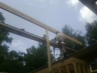 Carpenter setting a ridge beam over a new addition frame — Ice Dam Removal by Roofing Brothers in Barnwell
