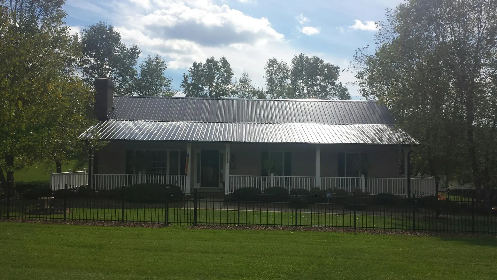 Gray metal roof on a brick ranch with a full width front porch — Gutter Guard Installation work by our crew in Barnwell